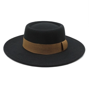 Detail of black wool felt flat top boater hat with a stylish dark brown grosgrain ribbon