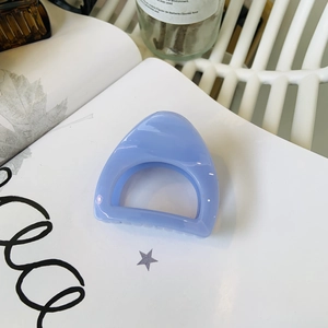 Light blue triangular cat ear hair claw clip in acrylic on a minimalist white background