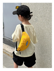 Close-up of yellow canvas kids chest bag featuring adjustable strap and buckle details
