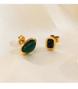 Détail de boucles d'oreilles asymétriques plaquées or 18K avec pierres verte et noire