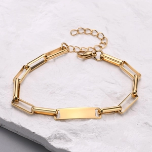Vista dettagliata del bracciale ID in acciaio inossidabile dorato con chiusura a moschettone