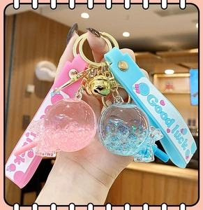 Close-up of pink and blue glowing lollipop keychains with bells and Good Luck straps