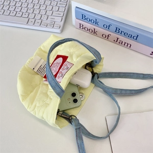 Vue détaillée du mini sac matelassé jaune avec bandoulière en denim et téléphone intérieur