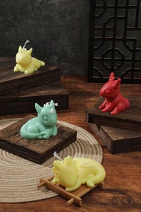 Artistic display of cute dragon-shaped scented candles in red, green, and yellow