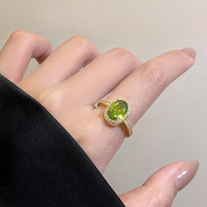 Macro shot of 18k gold plated ring featuring an oval green zircon with diamond accents