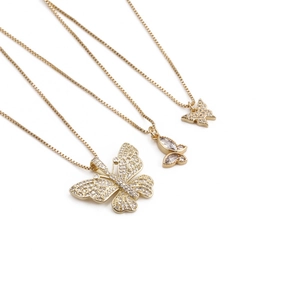 Three gold butterfly necklaces with marquise zircon stones and box chains on white background