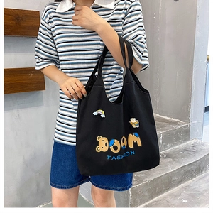 Detail der schwarzen Canvas-Tragetasche mit Bären-Patches und BOOM FASHION Bestickung