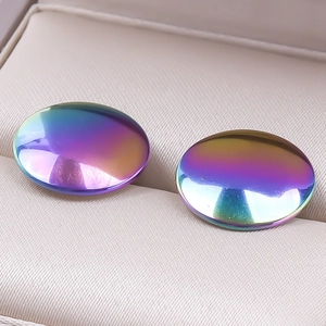 Close-up of iridescent 304 stainless steel round earrings in a beige jewelry box tray