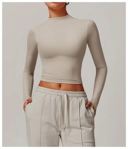 Detail of high-neck quick-dry slim fit yoga top in sand color and elastic fabric