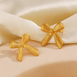 Chic 18K gold plated bow earrings with textured finish on soft silk background