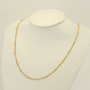 Minimalist gold plated stainless steel beaded chain necklace worn on a white neck bust