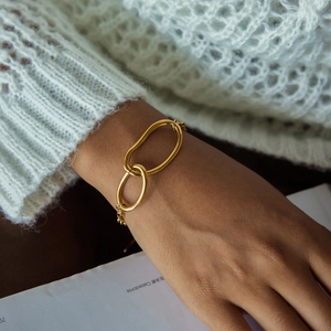 Elegant gold titanium steel bracelet featuring double interlocking oval rings on a thin chain