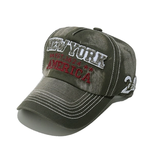 Macro shot of 3D embroidery detail on vintage washed olive green New York baseball cap
