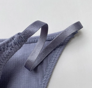 Close-up of purple ribbed cotton fabric with elastic satin strap and refined stitching