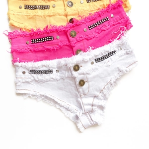 Detailansicht bunter Denim-Shorts mit Strasssteinen und ausgefransten Saumkanten und Nieten