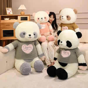 Large panda plush toy with colorful Love sweaters shown in a cozy home setting with a model