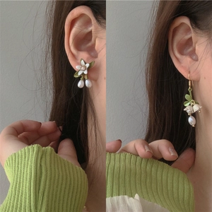 Pastel flower and lily of the valley earrings with pearls shown on a female model