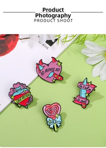 Detail of pop art enamel pins featuring heart daggers and love potion on a green background