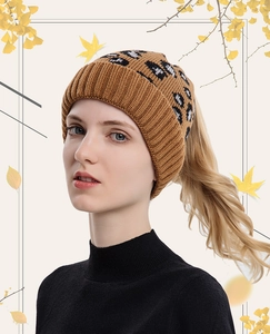 Close-up of leopard print knitted beanie showing the functional ponytail hole design