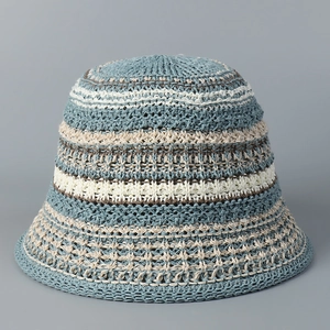 Close-up detail of crochet knit pattern on striped sun hat in blue, white, and khaki