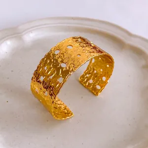 Brazalete ancho bañado en oro con textura martillada y diseño calado irregular