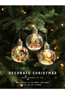 Close-up of a clear LED Christmas ornament featuring a mini Santa and tree on a pine branch