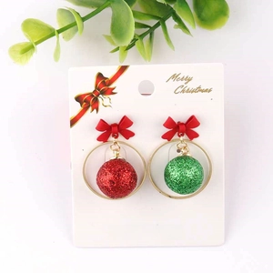 Detail of Christmas earrings featuring red green glitter balls and red ribbon bows