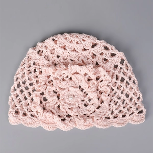 Détail de la texture crochetée à la main avec fleur en tricot 3D et perle de chapeau