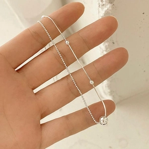 Detail of 925 sterling silver double layer necklace with snake chain and hammered bead