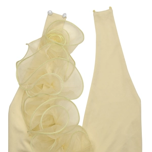 Détail de volants en organza beige et boutons perlés sur une robe dos nu sexy