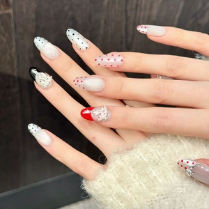 Handmade red and black polka dot press-on nails with 3D bow and puppy charm accents