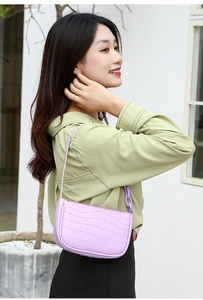 Detail of purple croc-embossed baguette bag with stylish chunky chain strap decoration