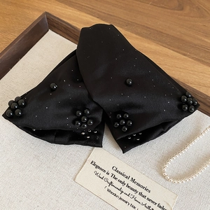 Detail shot of black satin triangle claw clip with black faux pearls and sparkling rhinestones