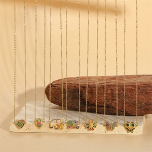 Gold titanium steel necklaces with colorful zircon animal and floral pendants on wood