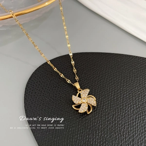 Close-up of golden windmill pendant necklace with sparkling micro-pave cubic zirconia