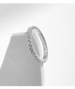 Macro detail of classic S925 sterling silver eternity ring with sparkling moissanite stones