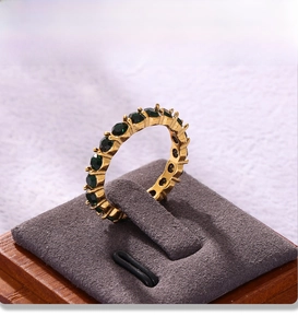 Dettaglio macro dell'anello eternity placcato oro 18K con pietre di vetro verdi