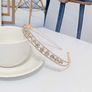 Elegant rose gold metal headband with sparkling crystals shown by a ceramic cup