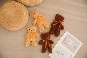Close-up of small teddy bear skins in light and dark brown with orange ribbon bows