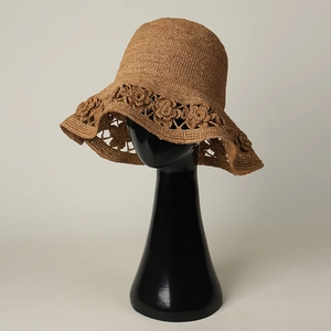 Handcrafted raffia straw sun hat featuring hollow floral crochet patterns for women