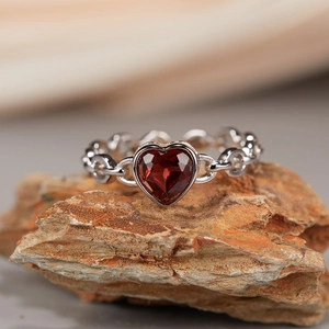 Detailed macro view of heart-shaped red garnet on a silver chain link ring band