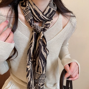 Detail of leopard and zebra print silk scarf necklace paired with beige knit sweater