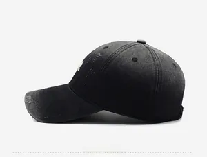 Side view of vintage washed black baseball cap with distressed edge and torn details