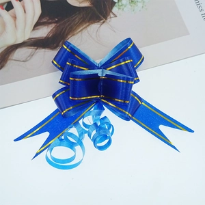 Close-up of a royal blue pull bow ribbon with gold edges for holiday gift packaging