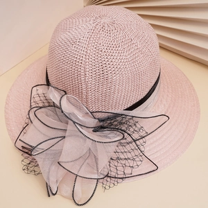 Pink woven sun hat with a large chiffon bow and black lace trim, 45-degree angle view