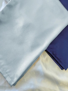 Detaillierte Makroansicht der seidigen Stofftextur in Blau, Marineblau und Creme-Weiß