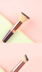 Dual-head makeup brush with rose gold ferrule and dual-tone bristles on a split background