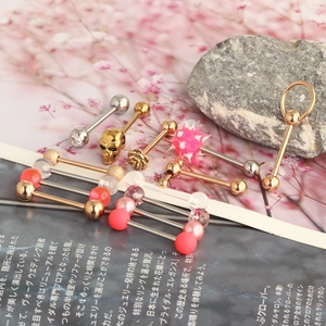 Macro shot of stainless steel tongue rings with skull and rose decorative ends