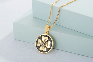 Detail of a golden tree of life pendant featuring black enamel and intricate relief