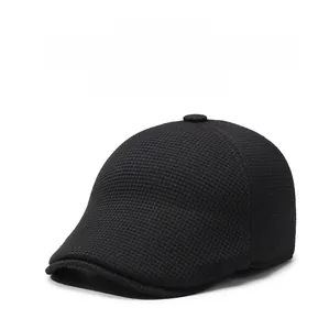 Close-up of black men's newsboy hat featuring honeycomb texture and metal logo